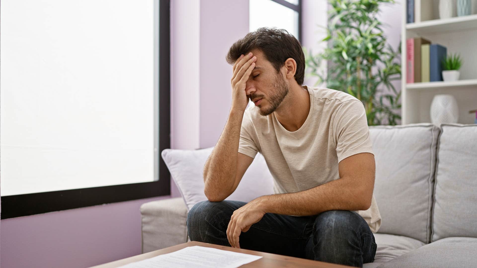 man dreading unexpected expenses looking at bill