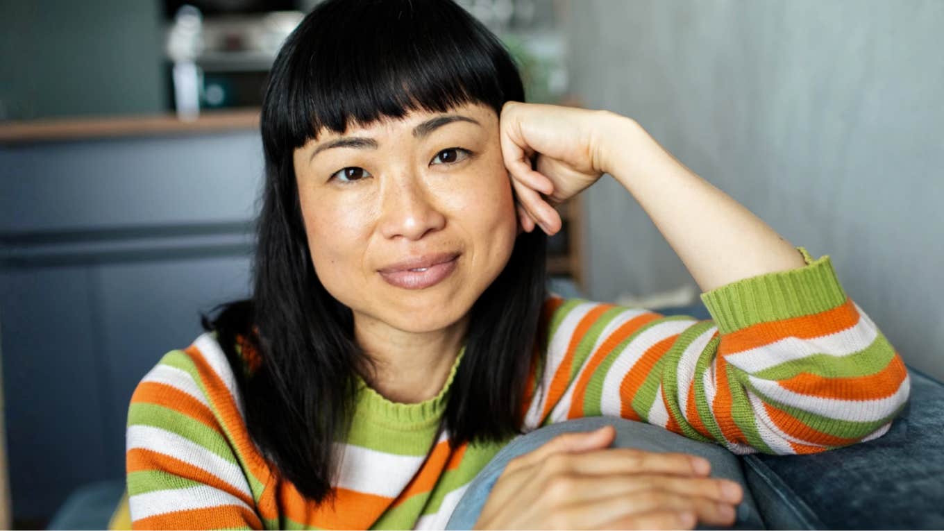 Smiling woman in striped sweater is naturally calm and peaceful 