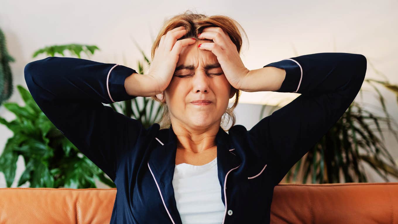 Woman holding her head in pain, illustrating migraine symptoms and warning signs for headaches that feel different or severe