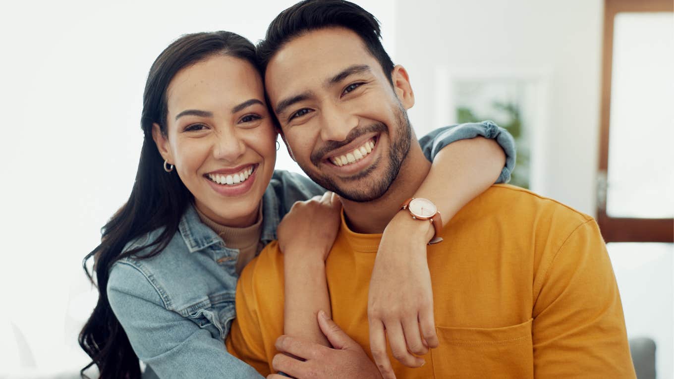 high-value man hugging his partner smiling