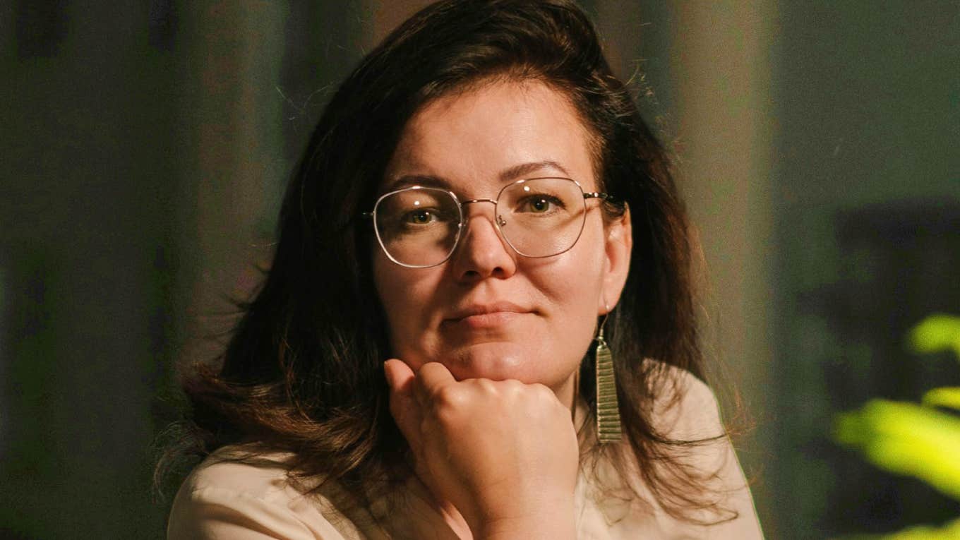 Quiet introverted woman resting her hand on her chin, showing the calm confidence and thoughtful behaviors highly respected introverts use to build strong relationships.