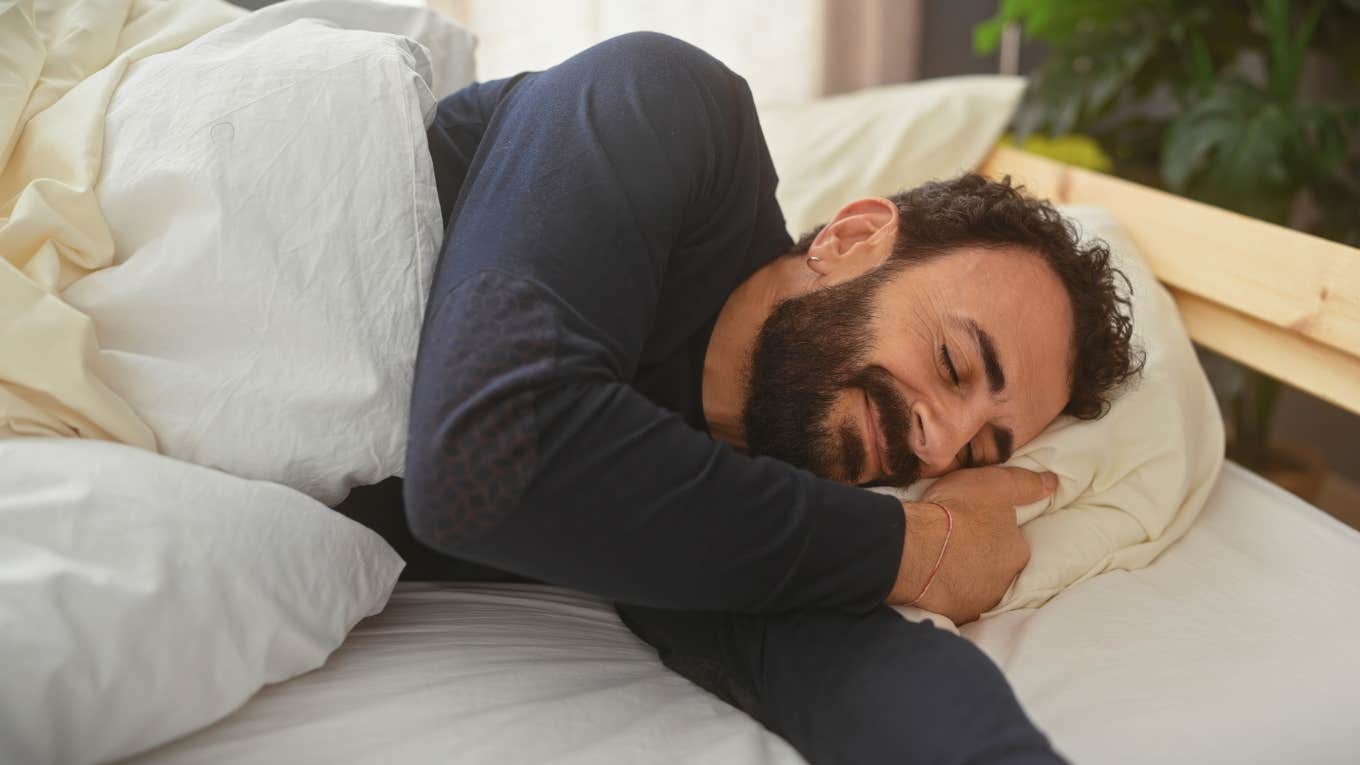 smiling man asleep in bed alone without wife