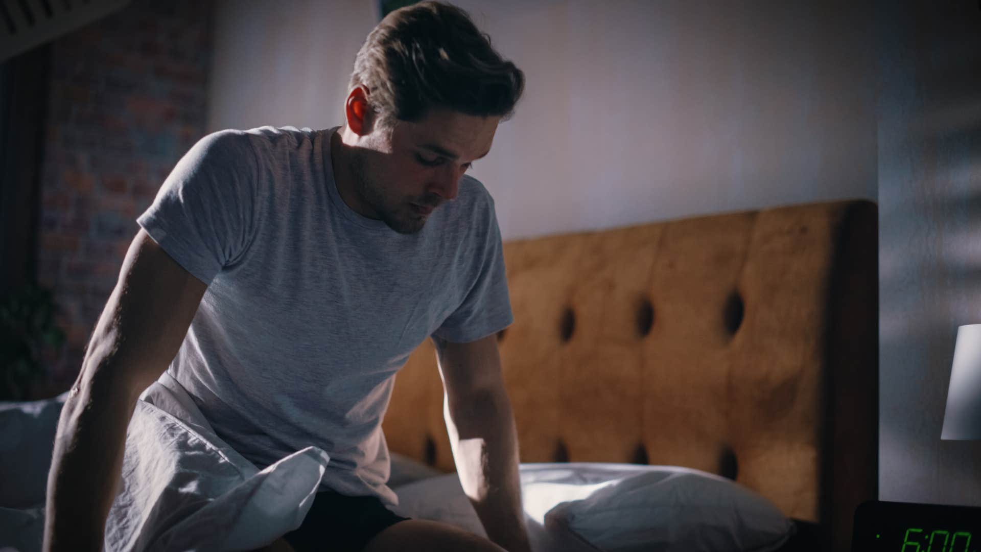 upset man sitting on the edge of the bed