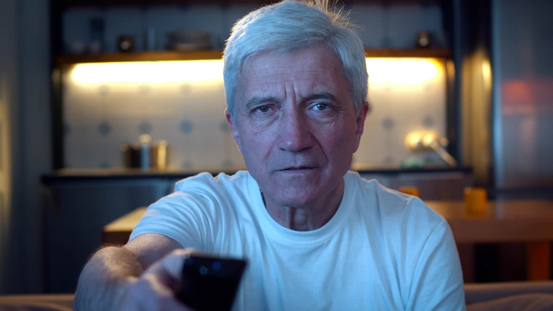 man coping with escapism watching tv on the couch