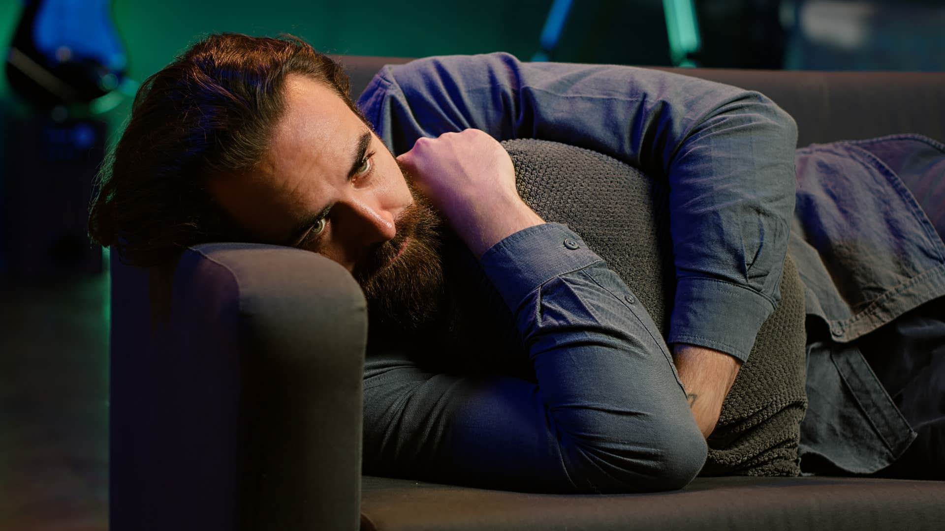 frustrated man curled up on couch alone