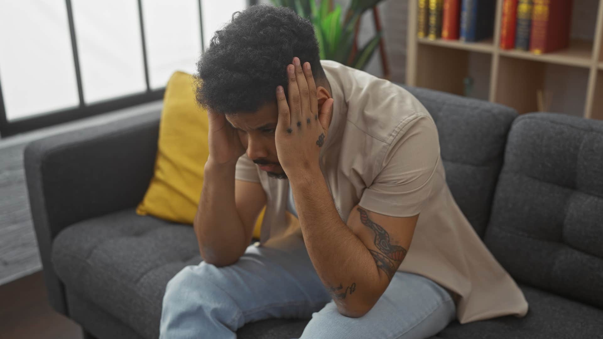 stressed man deep in thought on the couch