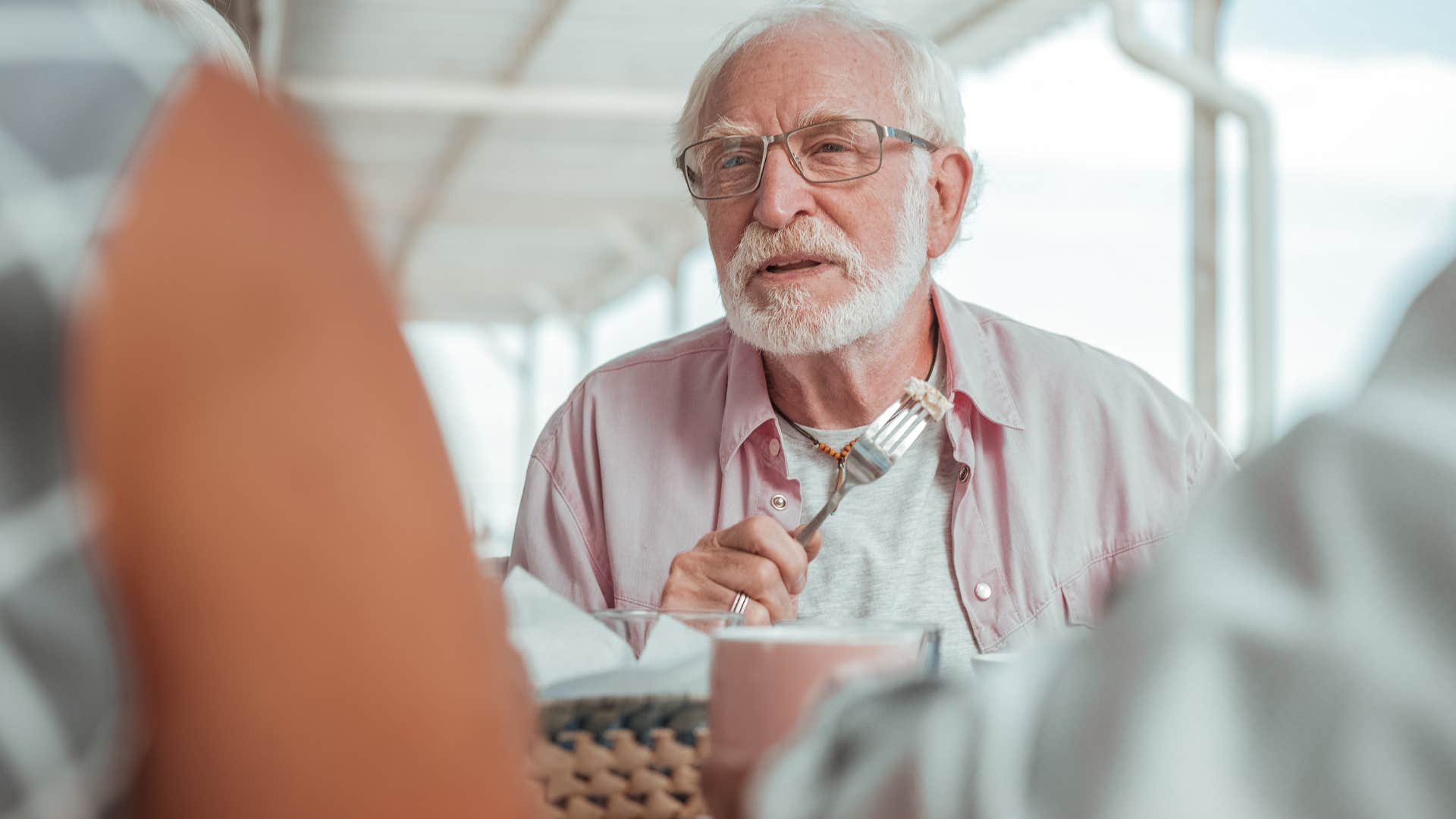 man who defends his partner talking to friends at dinner