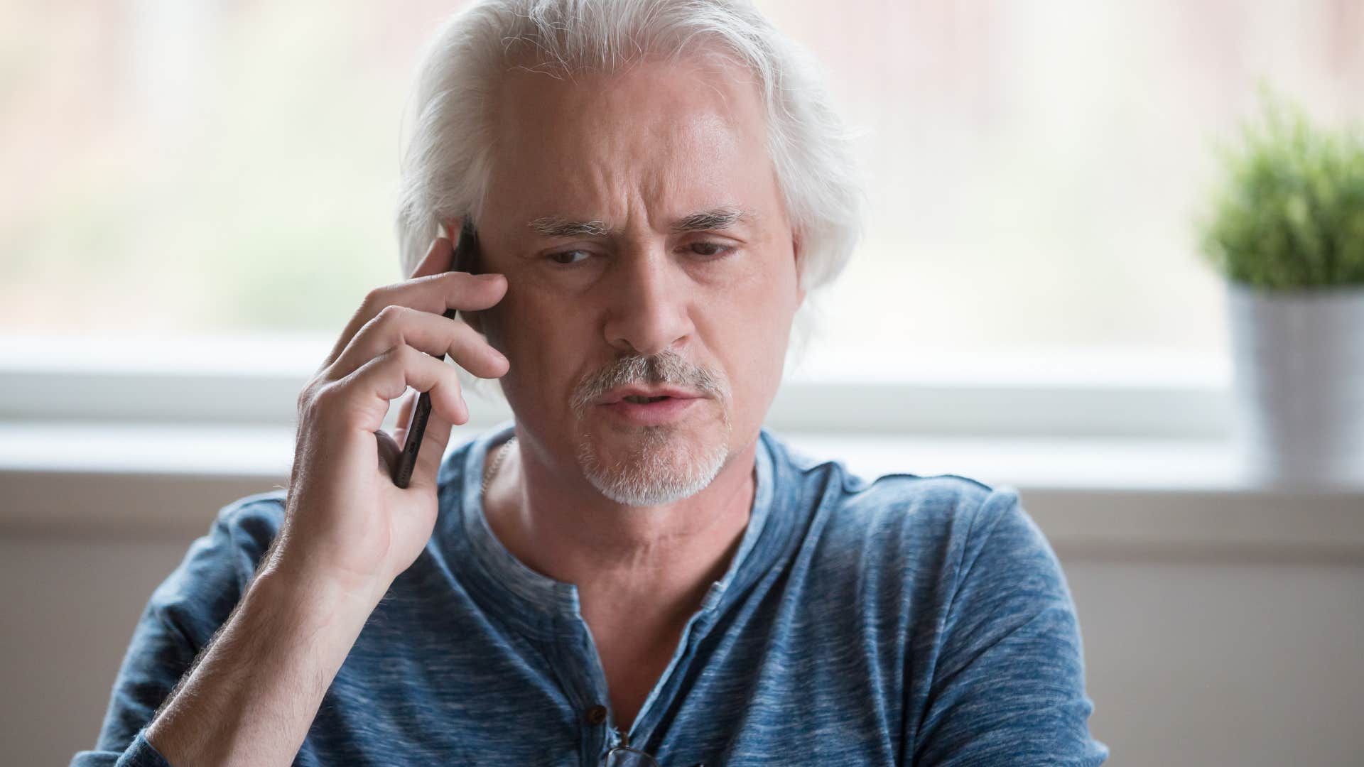 man gaslighting person on phone saying you sound crazy right now
