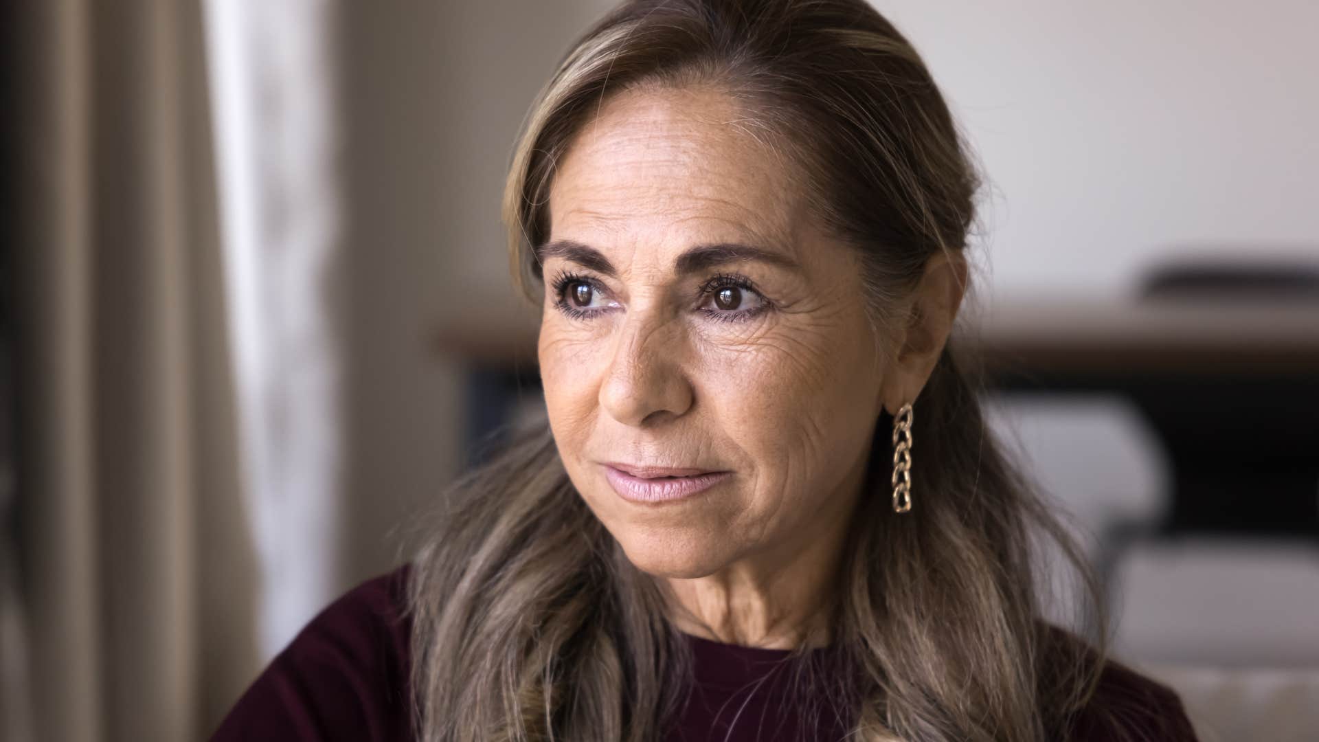 Woman who's lost purpose looking out a window.