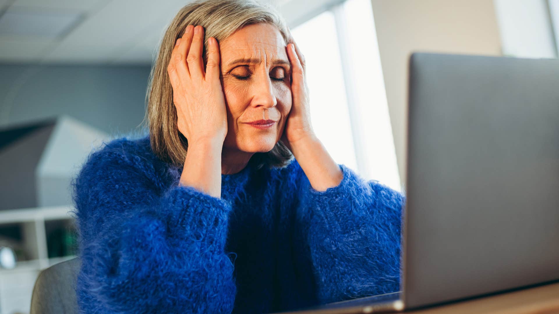 woman who's mentally overwhelmed looking at her laptop