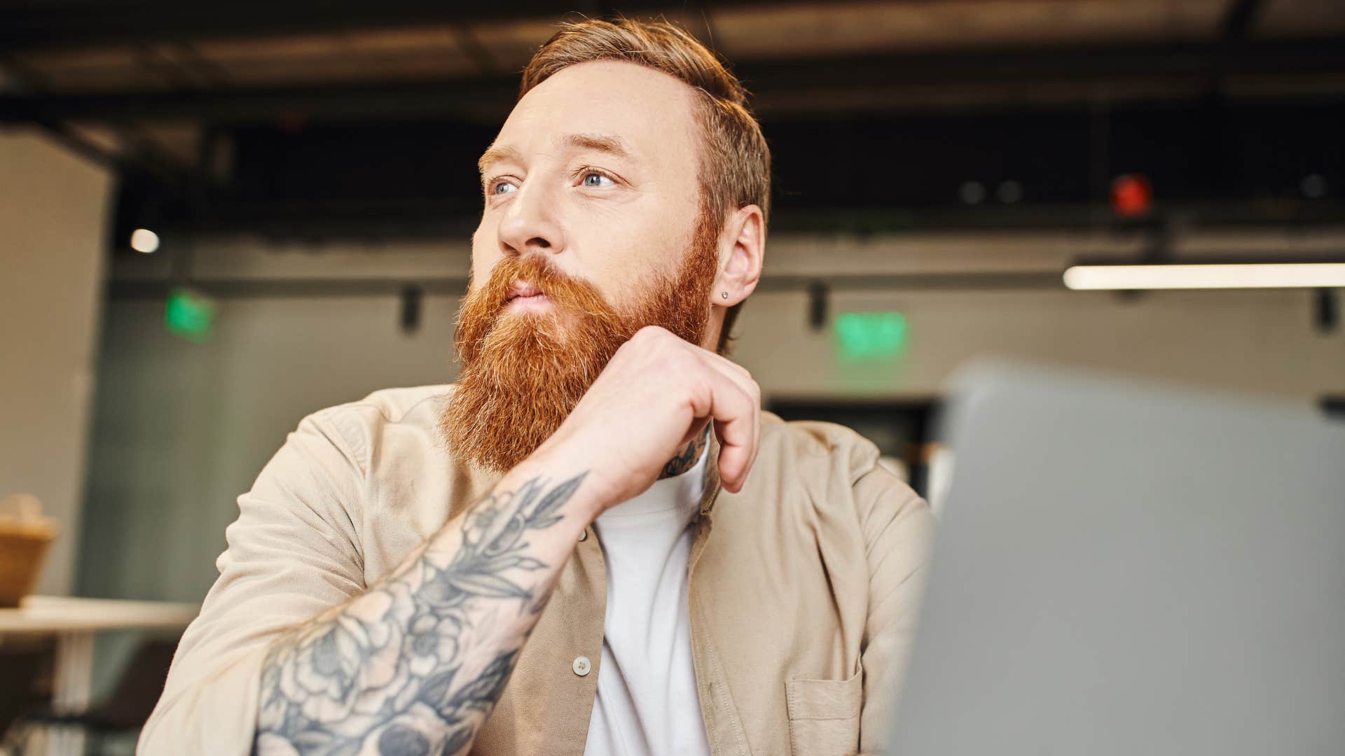 man thinking while working on laptop