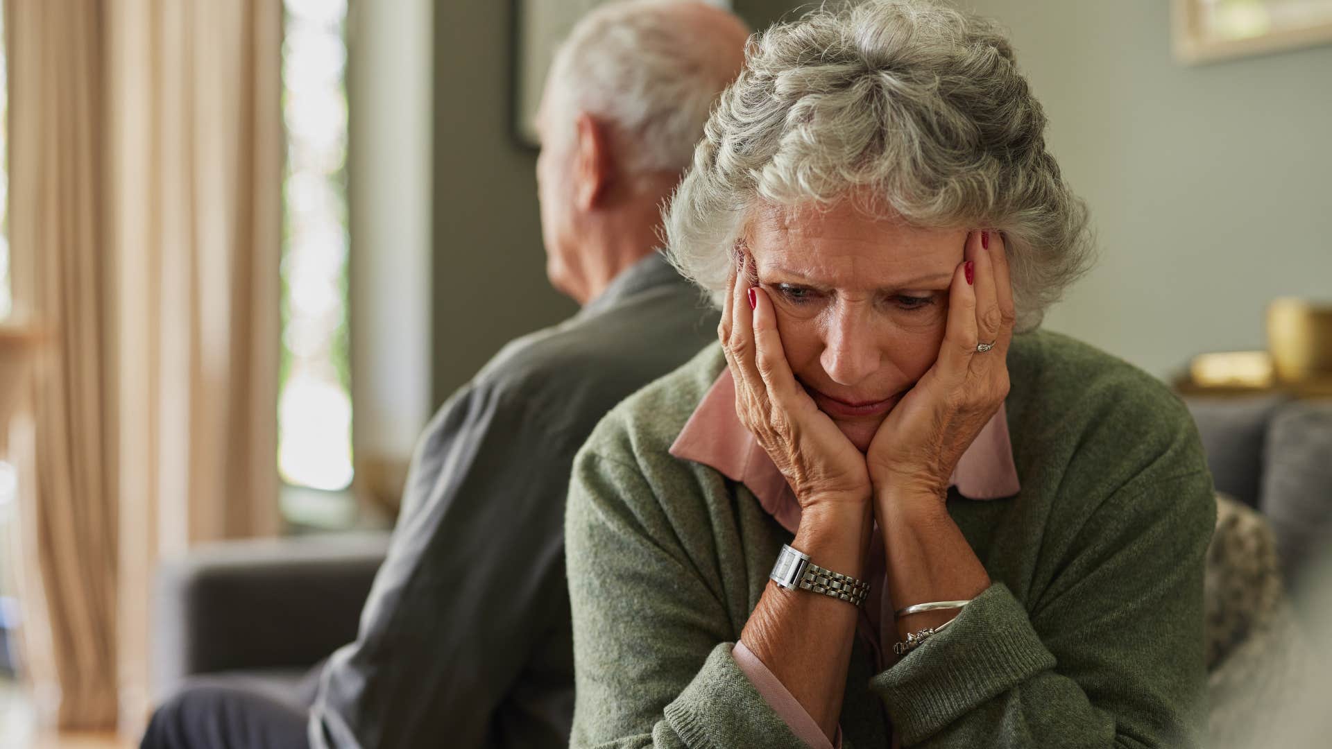woman suppressing uncomfortable feelings sitting away from her partner