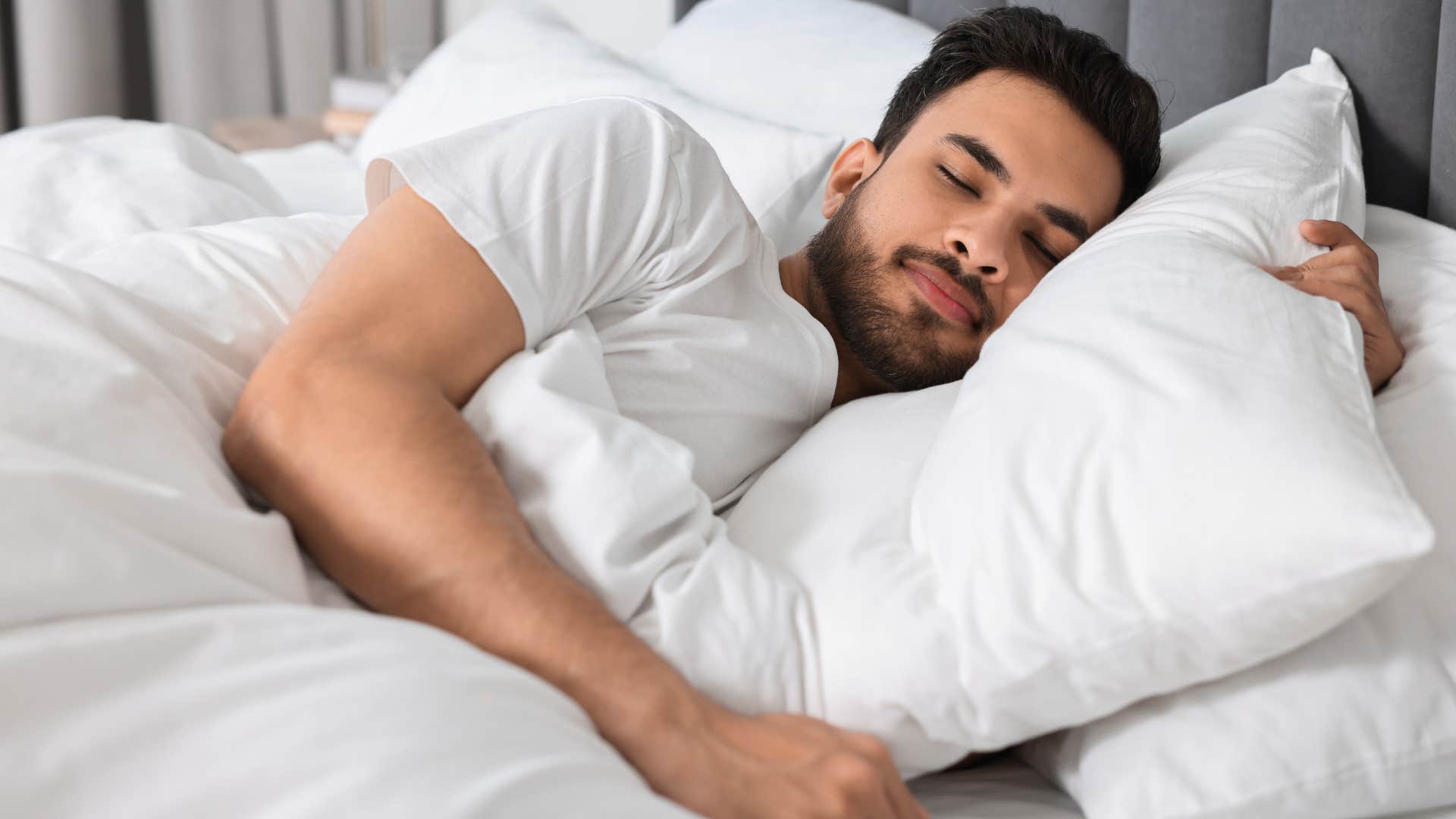 very empathetic man smiling and lying in bed