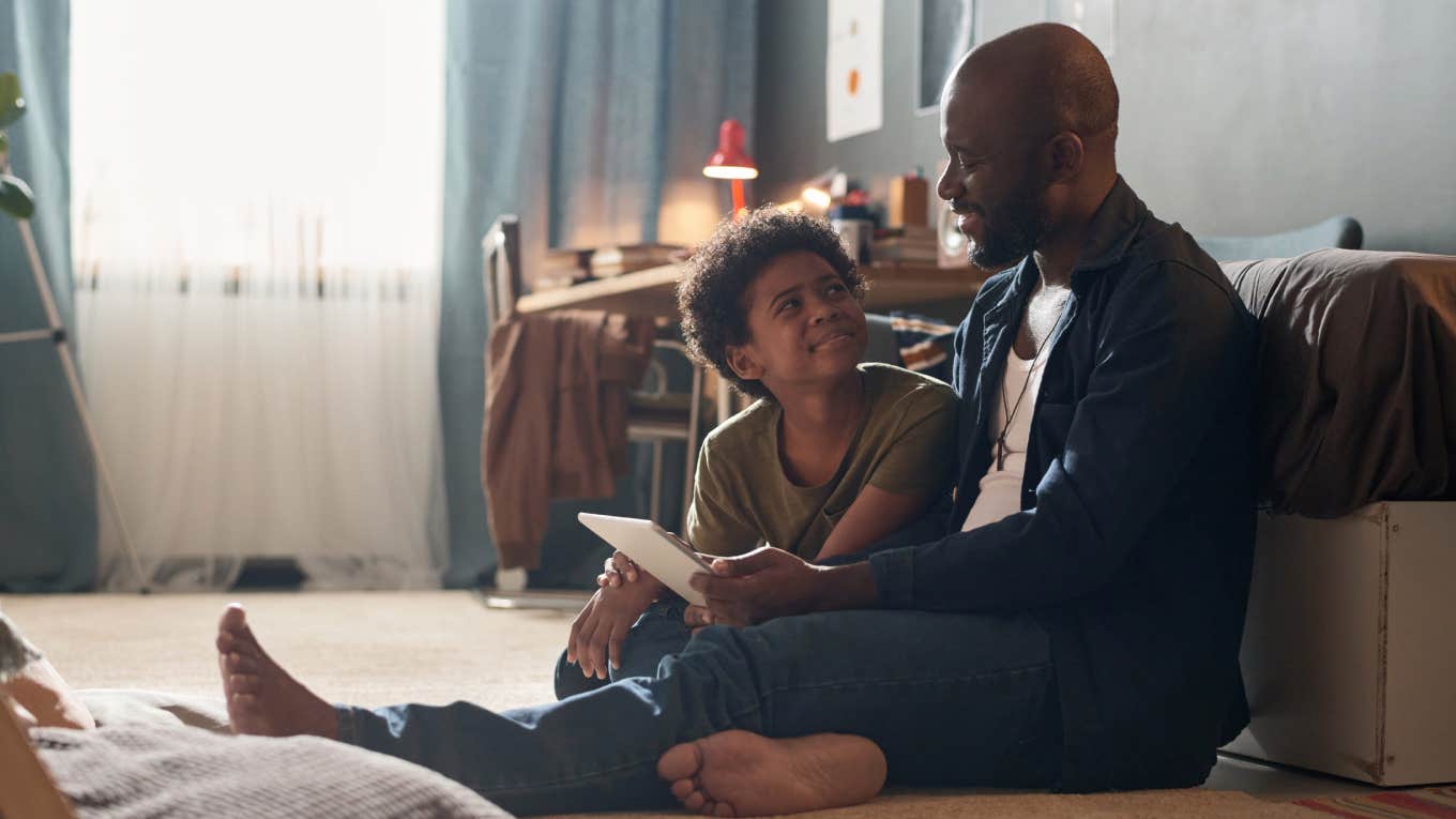 dad talking to son sitting on the floor
