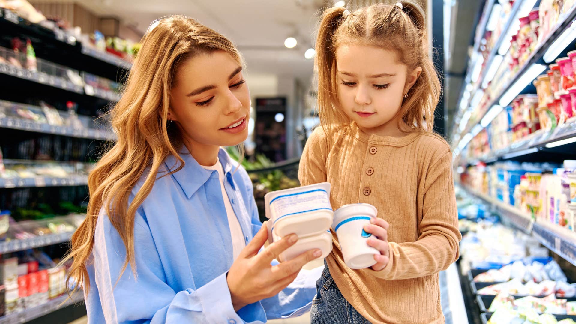 mom telling young daughter let's wait until it's on sale at the grocery store