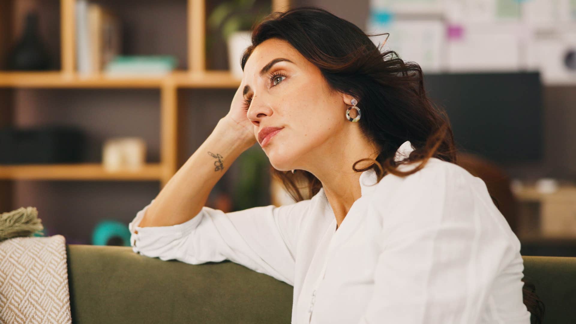 Woman looking upset at home with a burnt-out candle.