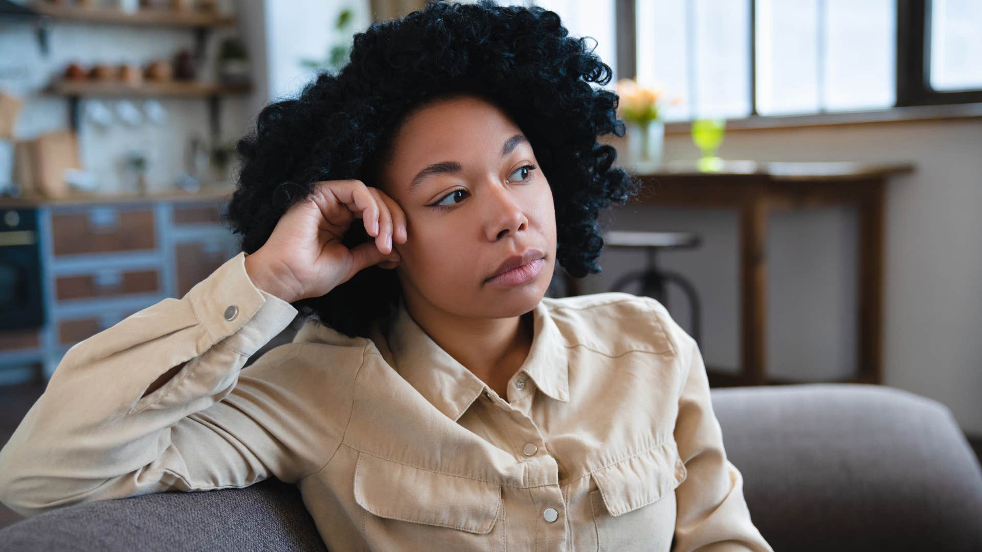 Woman sitting in a home with no personal touches.