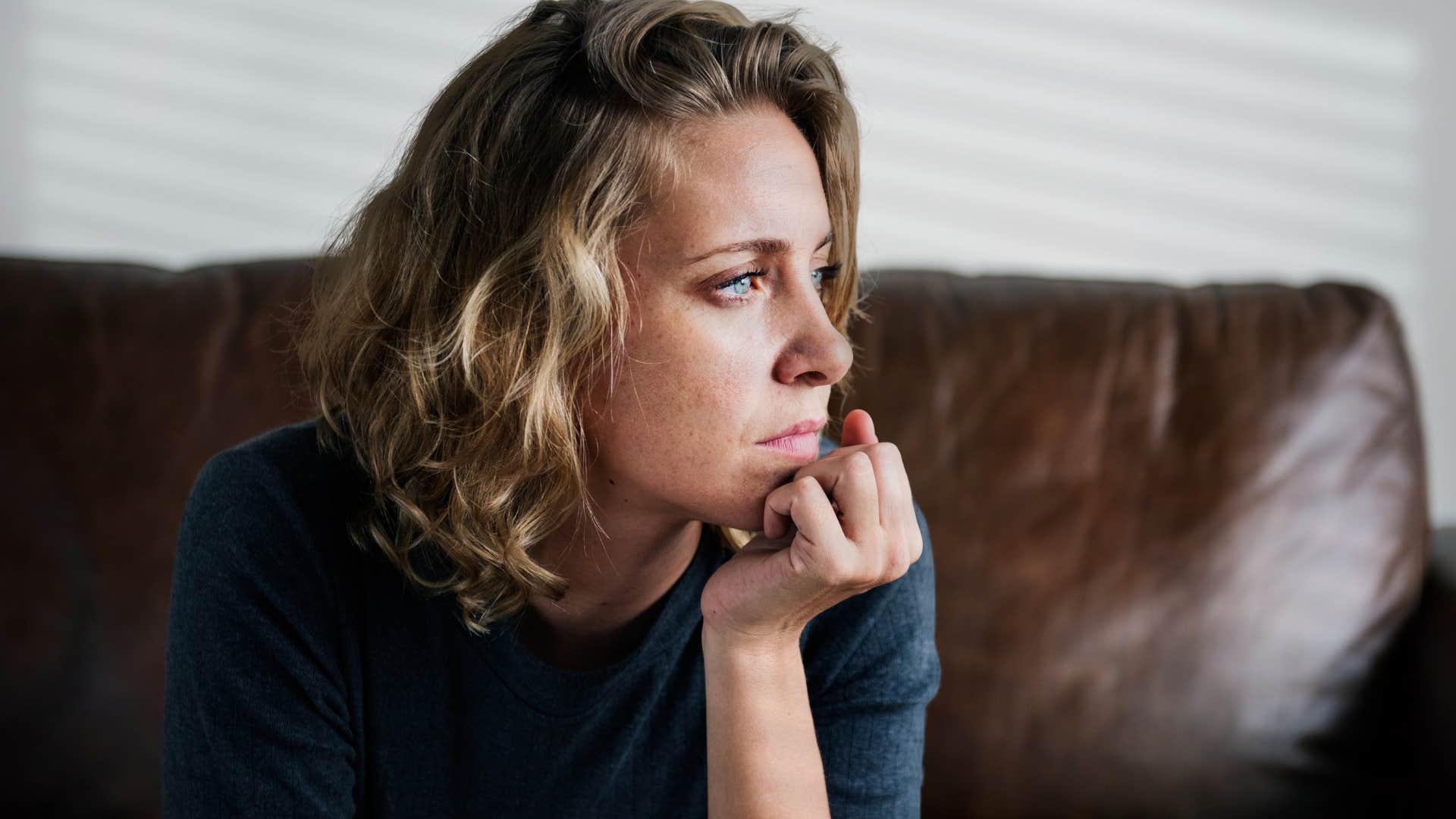 Woman sitting at home with a nonintuitive furniture set-up.