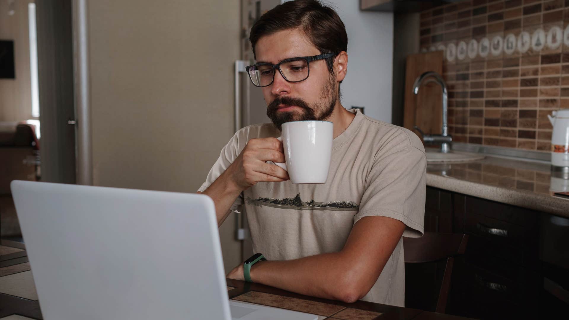 Man with tons of empty coffee cups working at home.