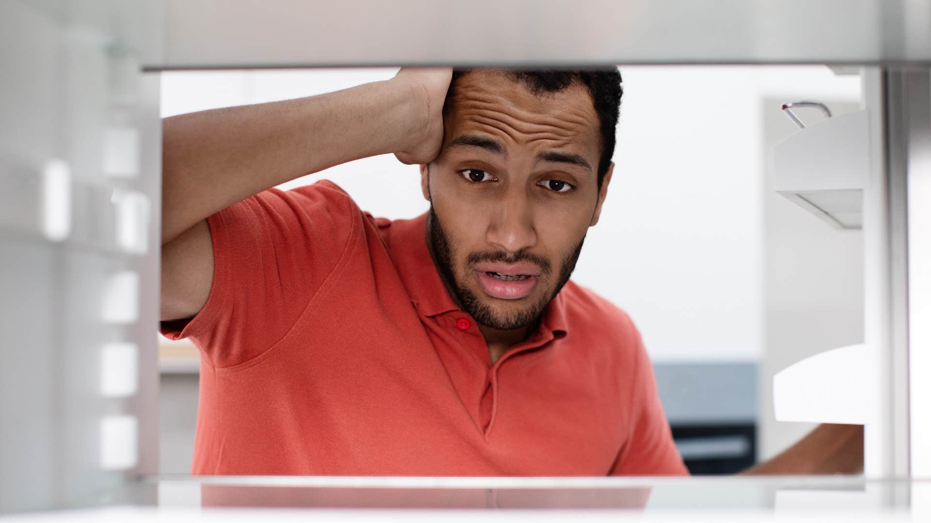 stressed man looking in an empty fridge