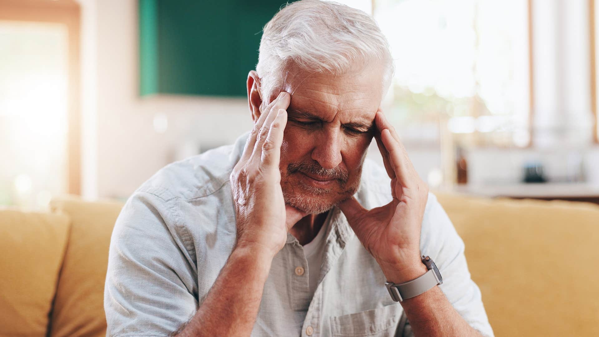 stressed man holding his head at home