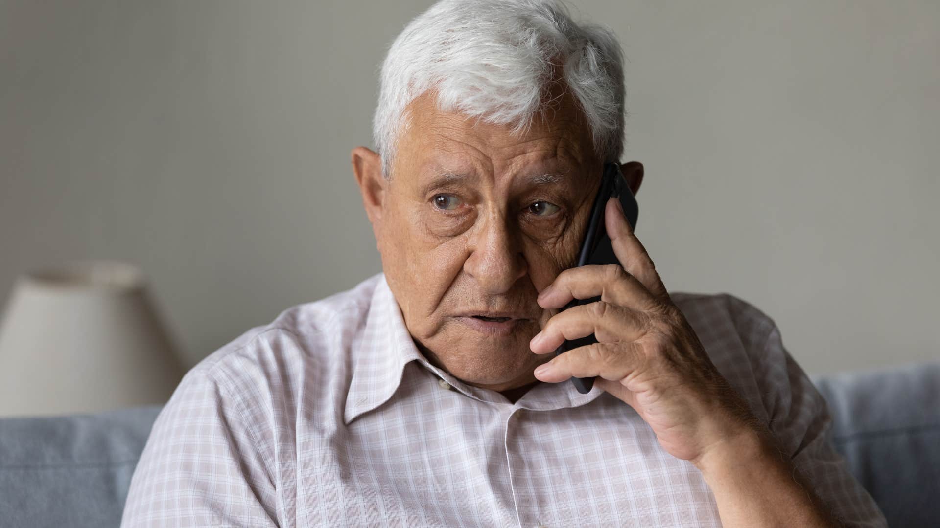 older man who forgets small things talking on the phone