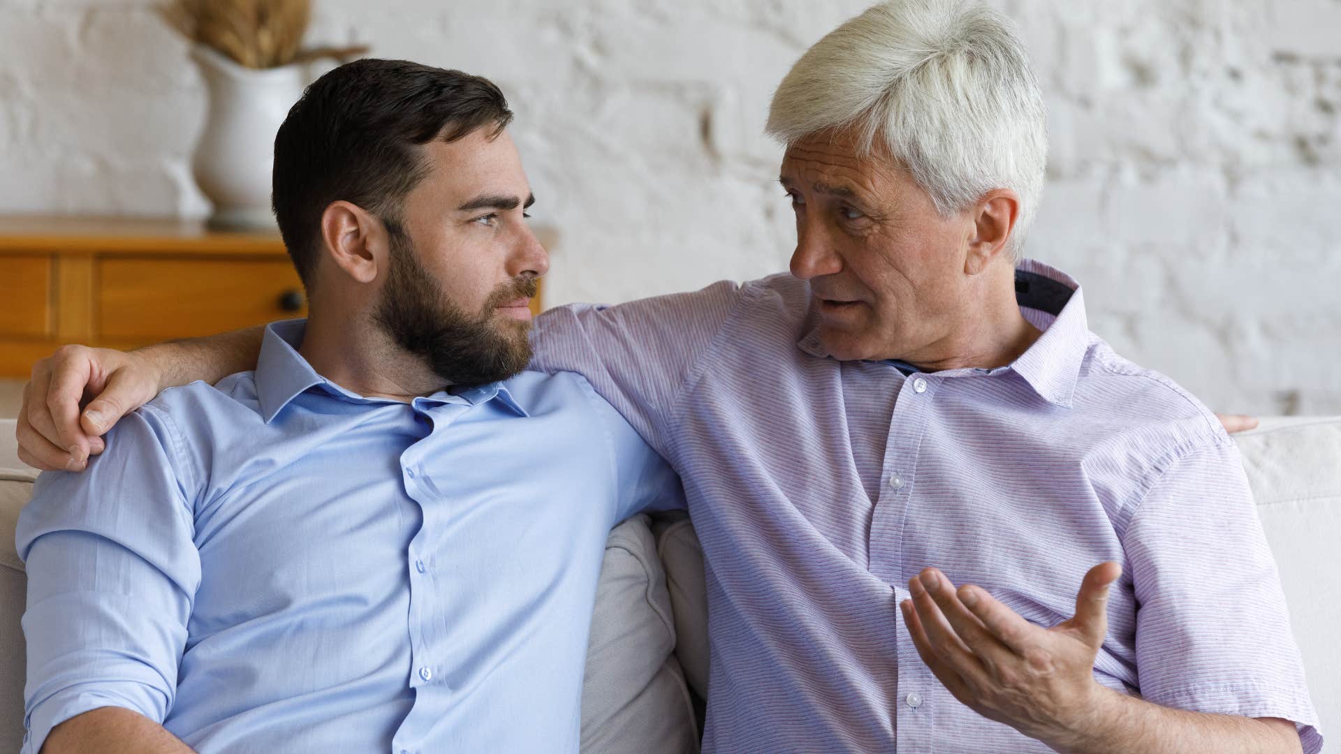 older man downplaying his struggles talking to his adult son