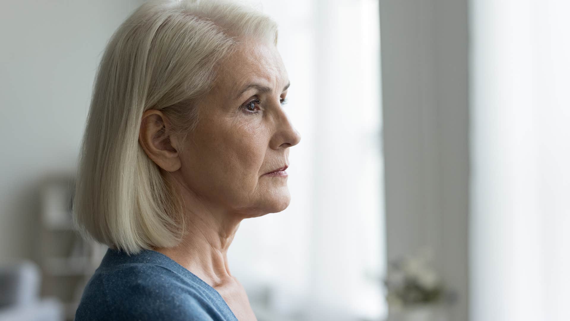 sad older woman watching adult child leave her home