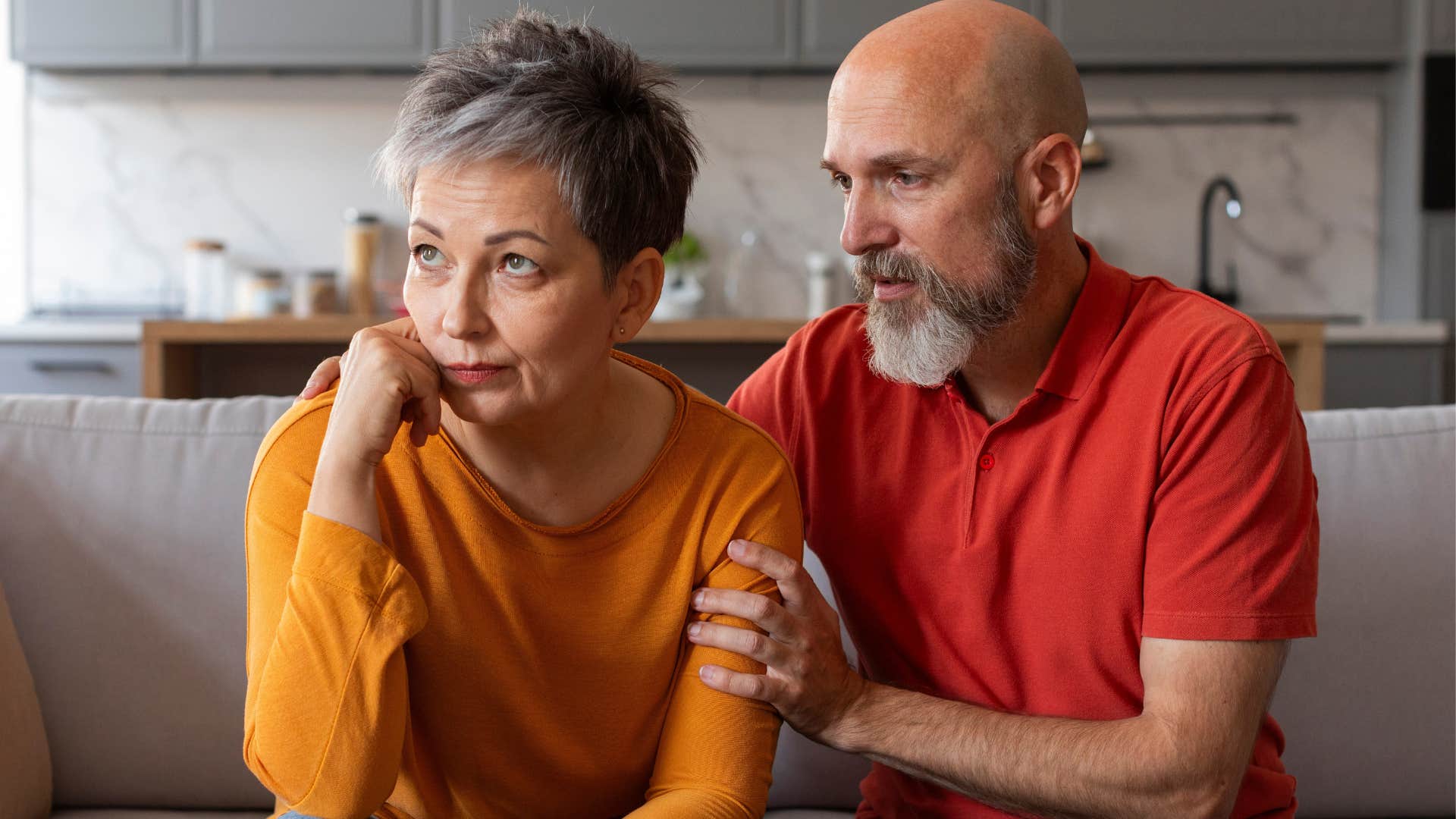Woman sitting by her husband who's saying "that's my fault, I'm sorry."