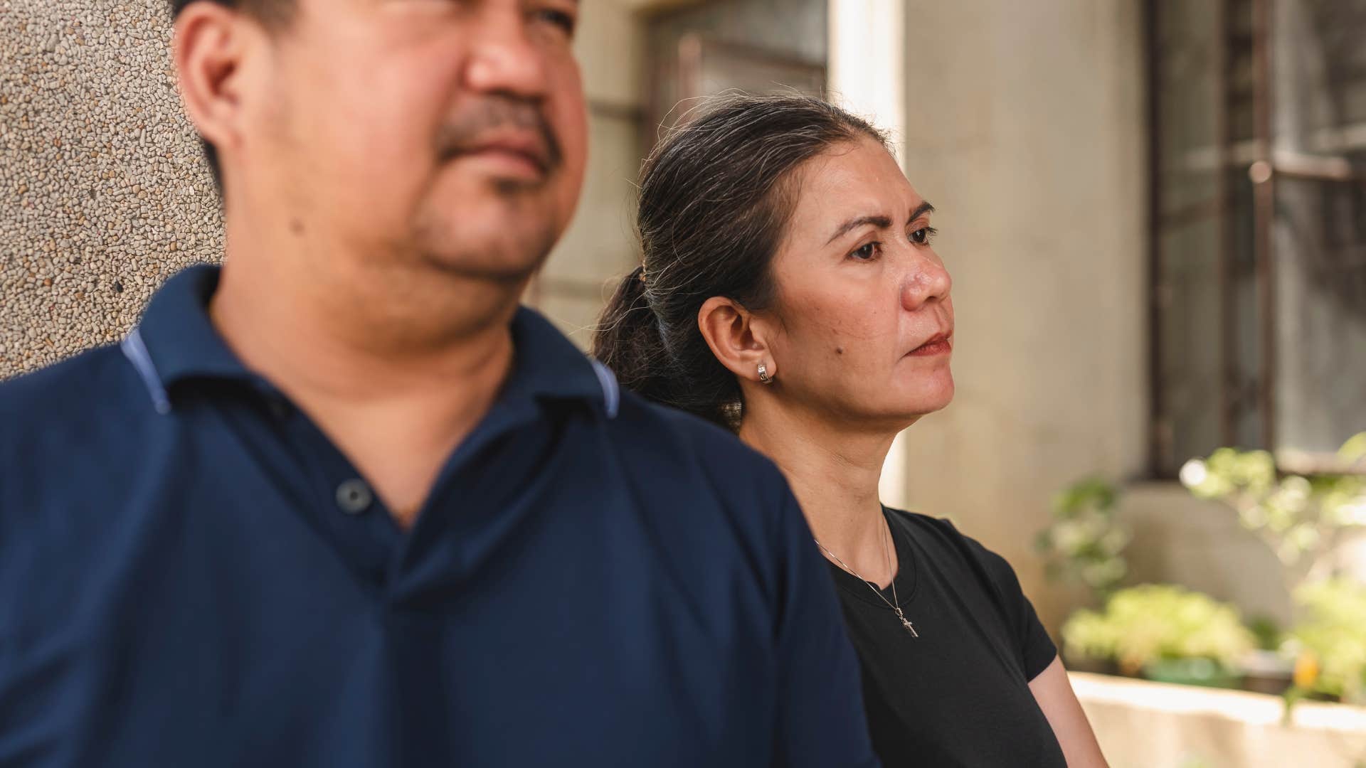 older couple who's drifted away from friends standing outside