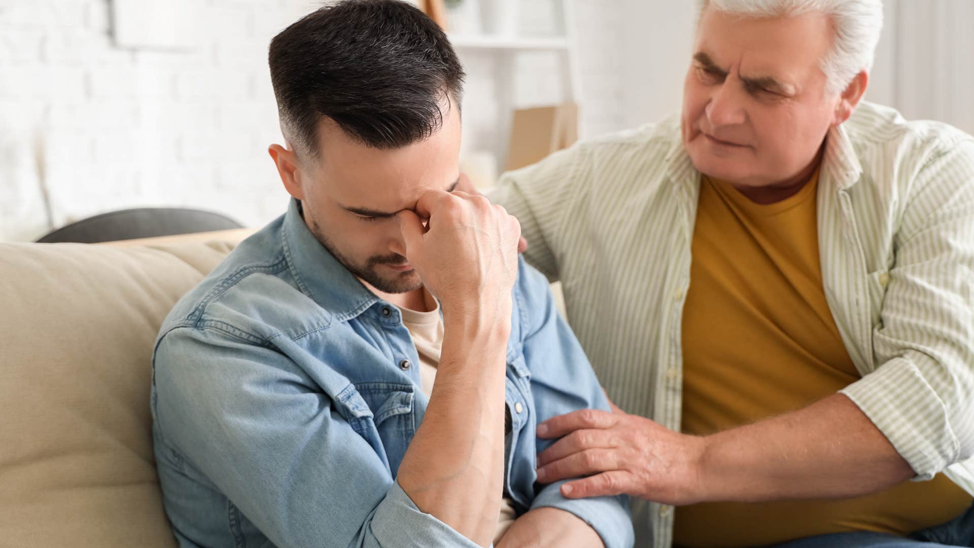 stressed man being comforted by older father