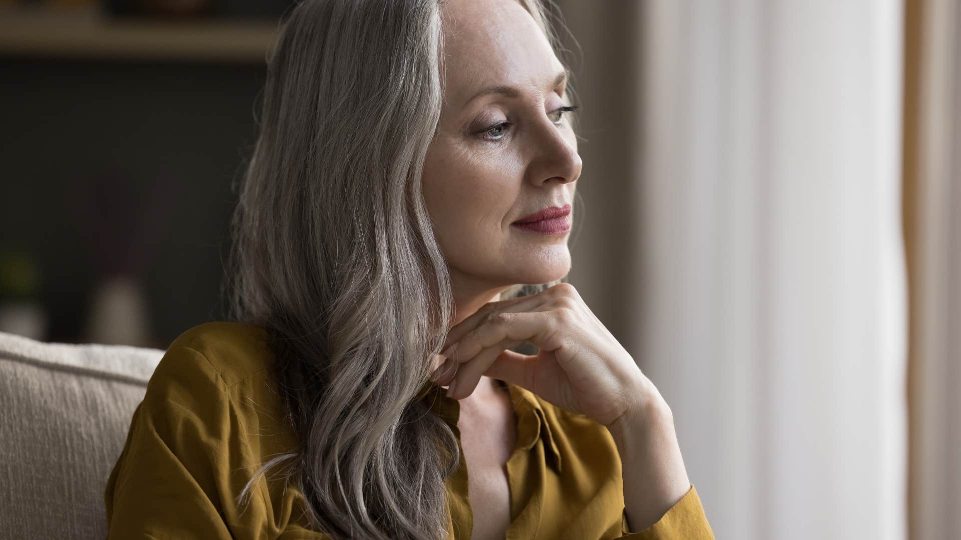 woman feeling nostalgic looking out window