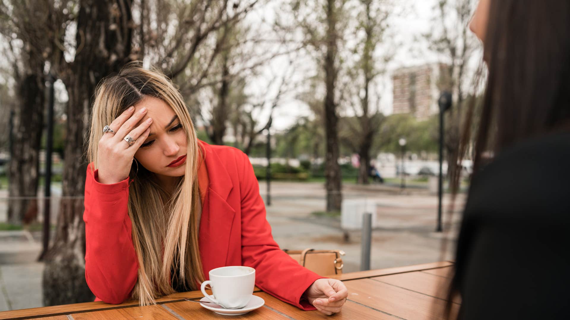 woman feeling annoyed having coffee with friend