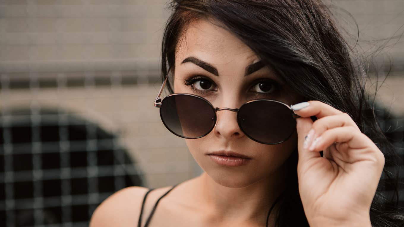 woman who lies lowering her sunglasses
