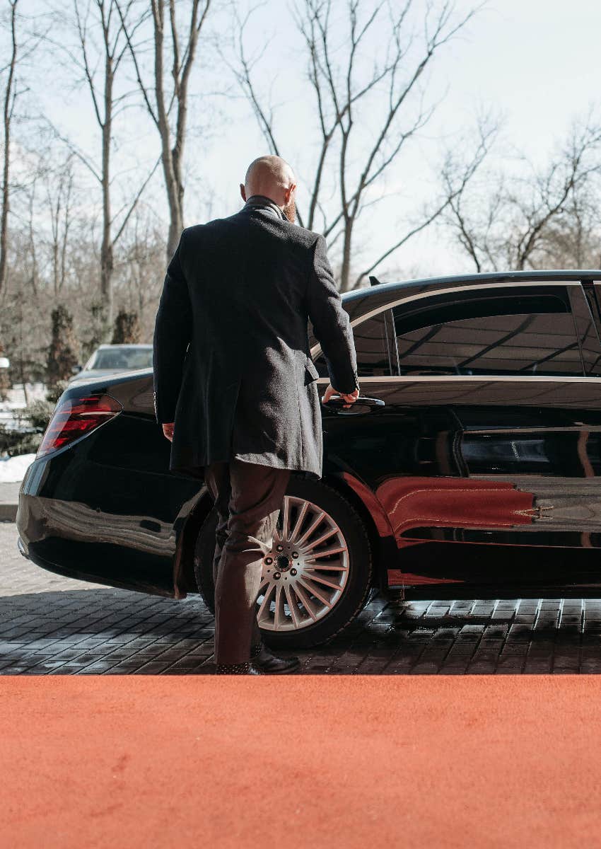 chauffeur opening door to private car 