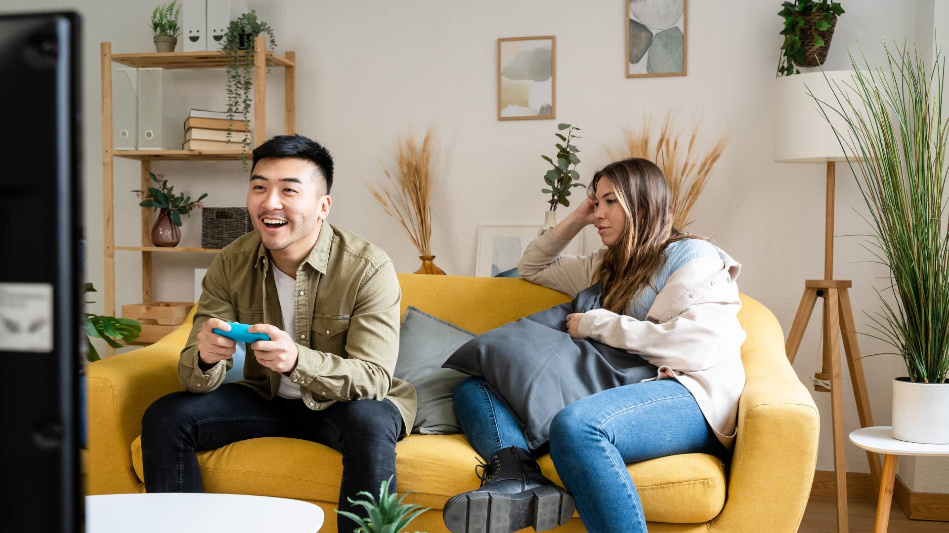 man neglecting emotional intimacy as he games as woman looks annoyed