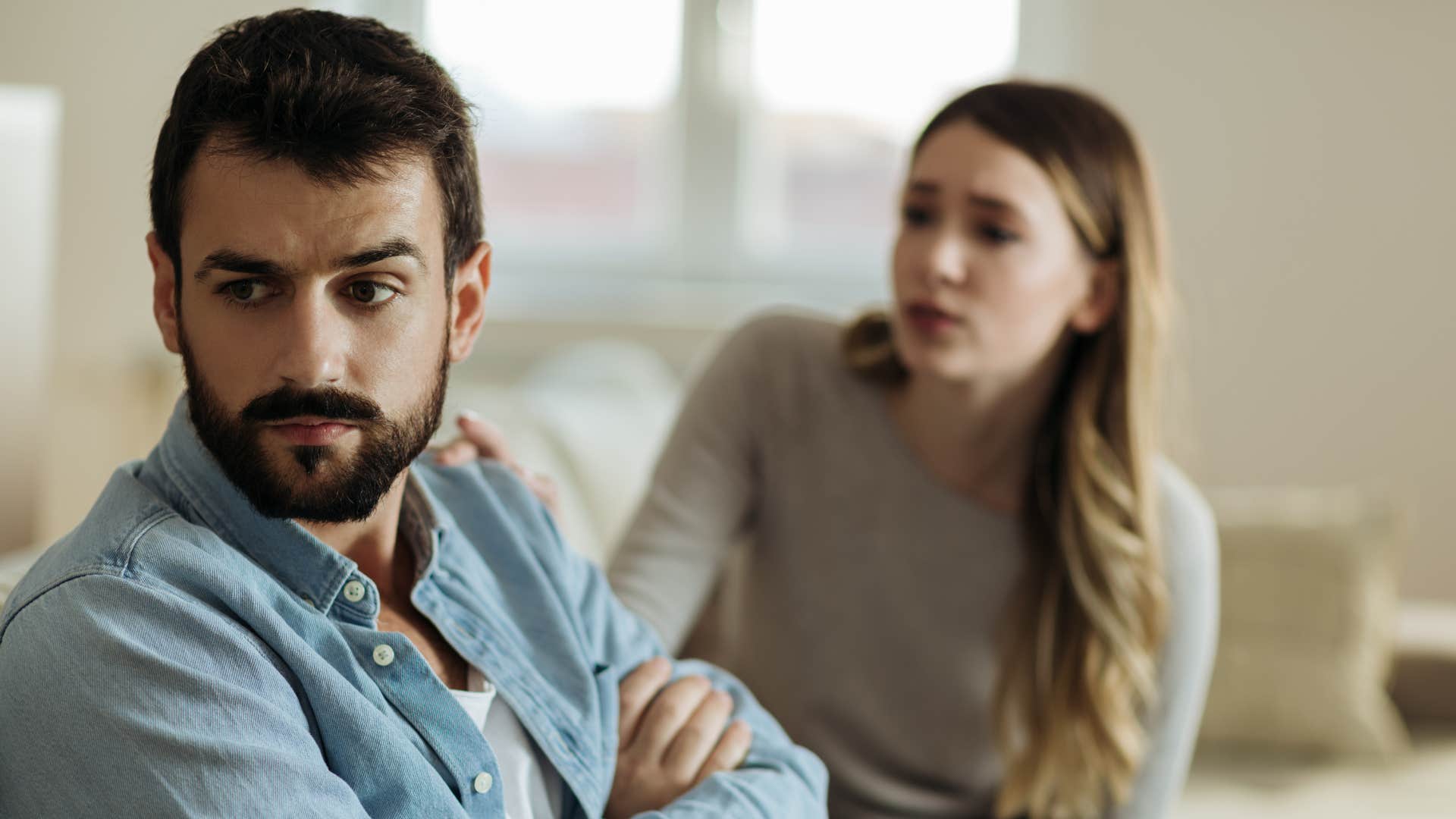 man ignoring woman as he refuses to listen actively