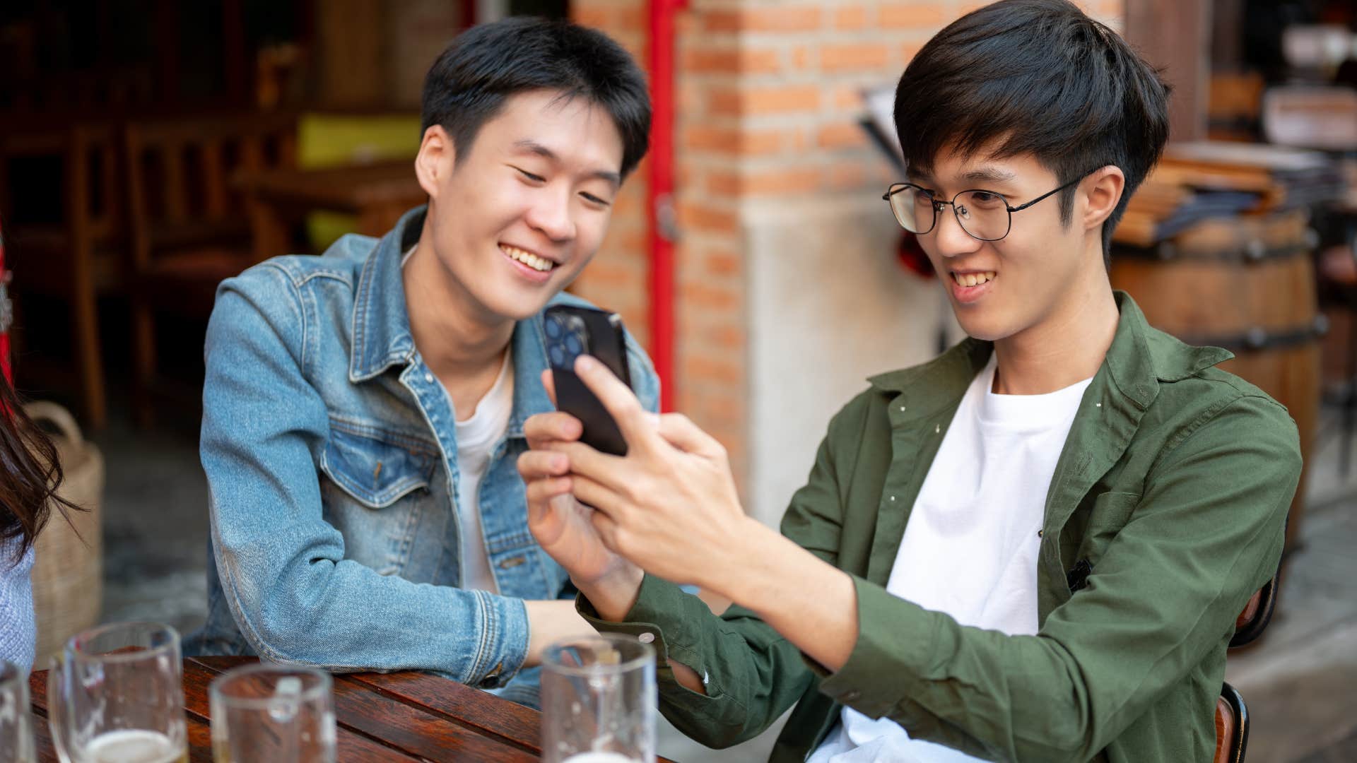 man in jean jacket prioritizing others over their marriage as he hands out with friends