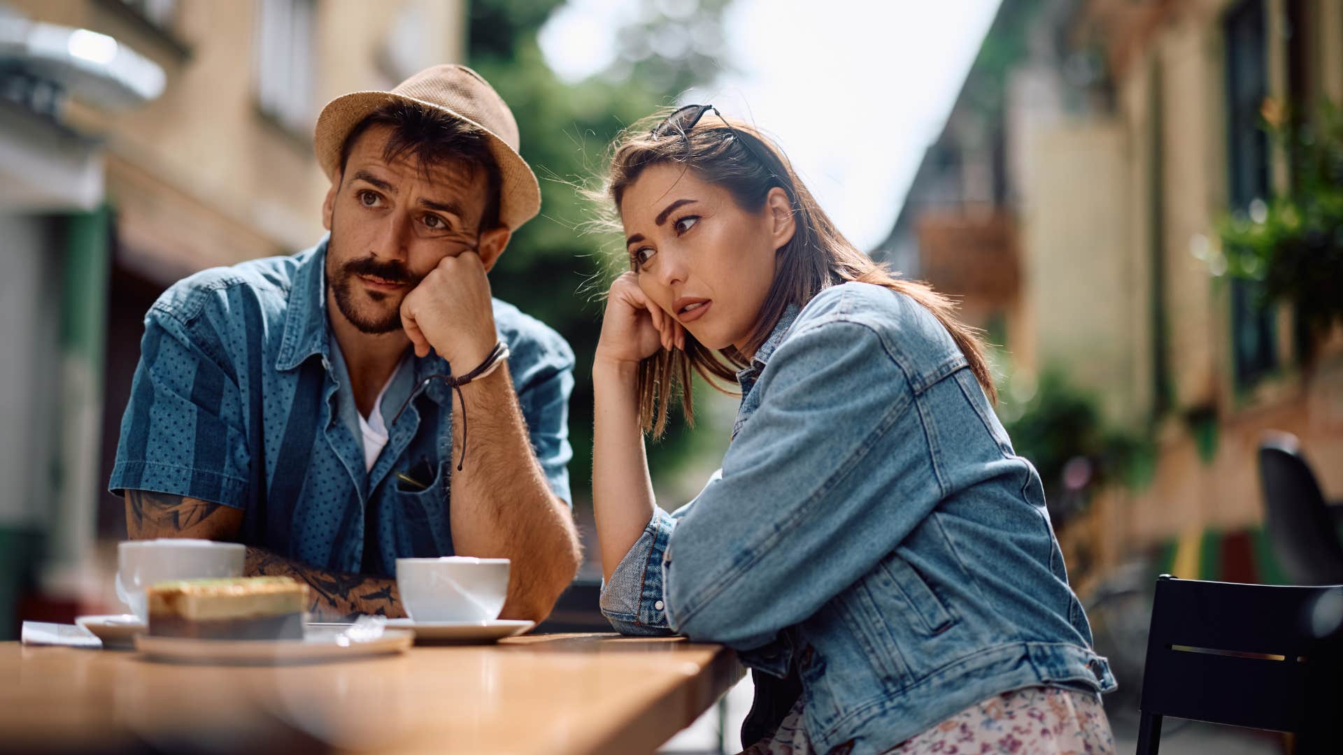man showing less enthusiasm on date as couple looks bored