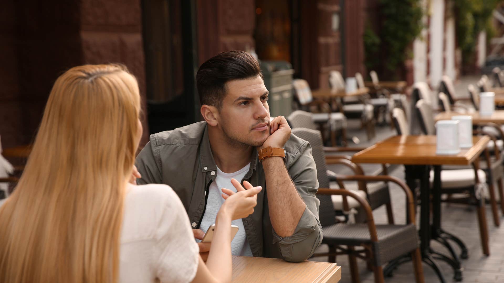 man looking bored on date as he stops asking questions about her life