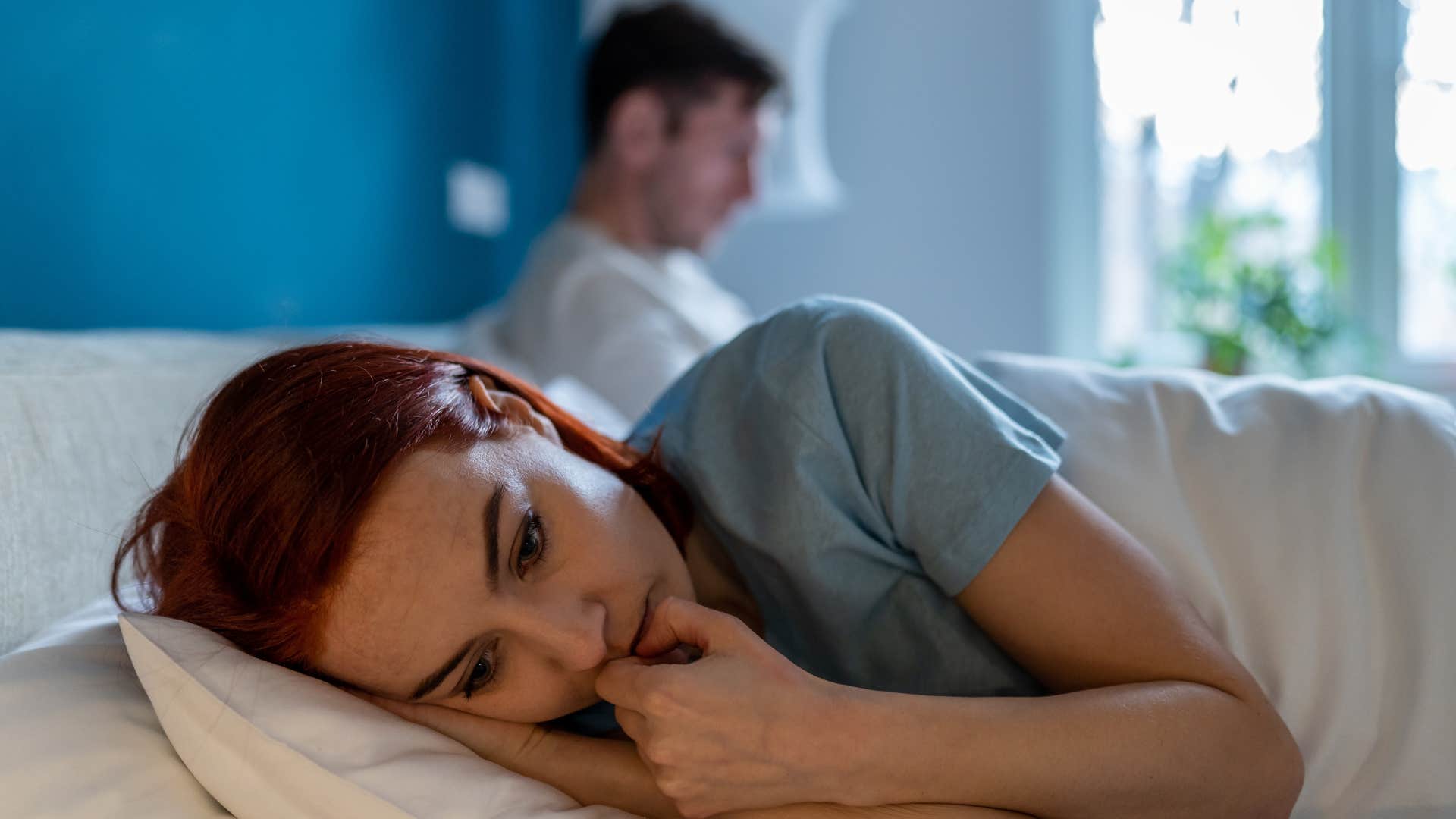 woman in gray looking upset while laying down as man stops noticing the little things about her