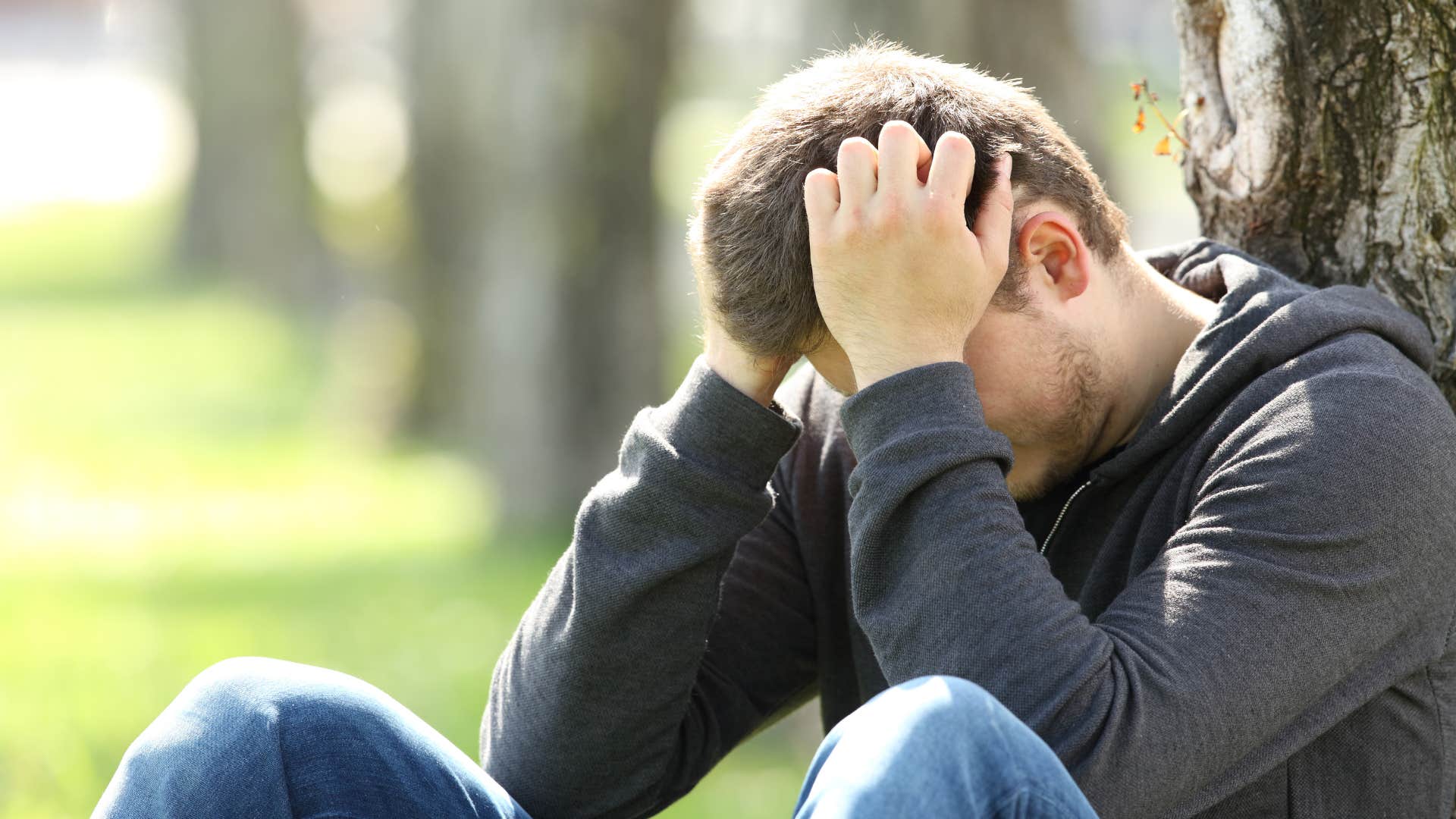 man feeling ashamed head in hands