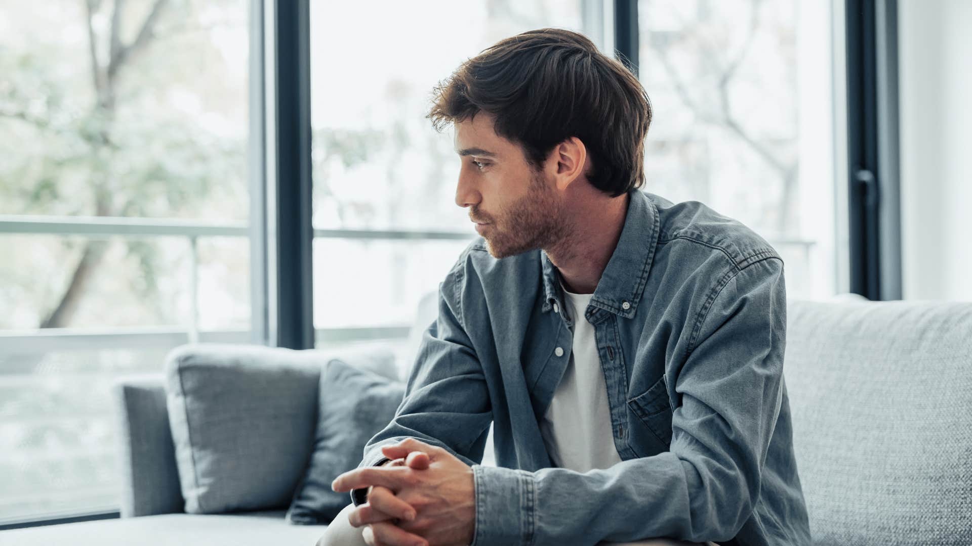 lonely man sitting on couch at home