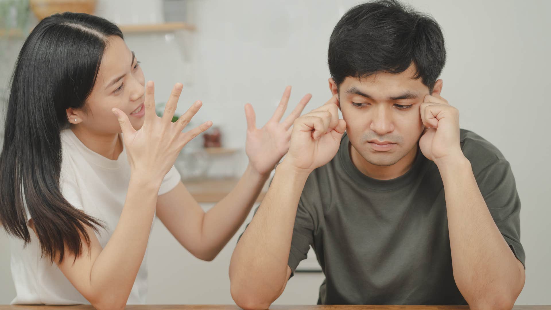 man plugging ears avoiding conversations about vulnerable emotions with wife