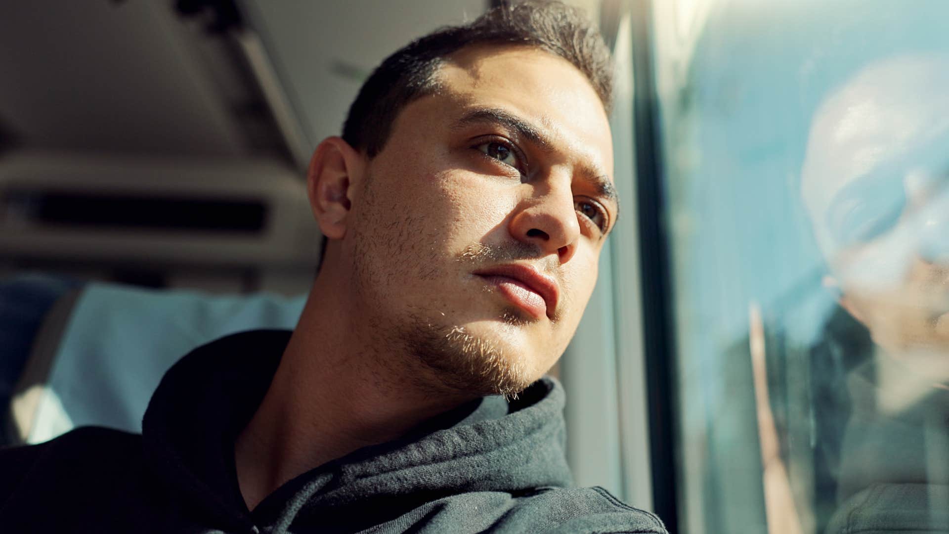 self-sabotaging man looking out a window