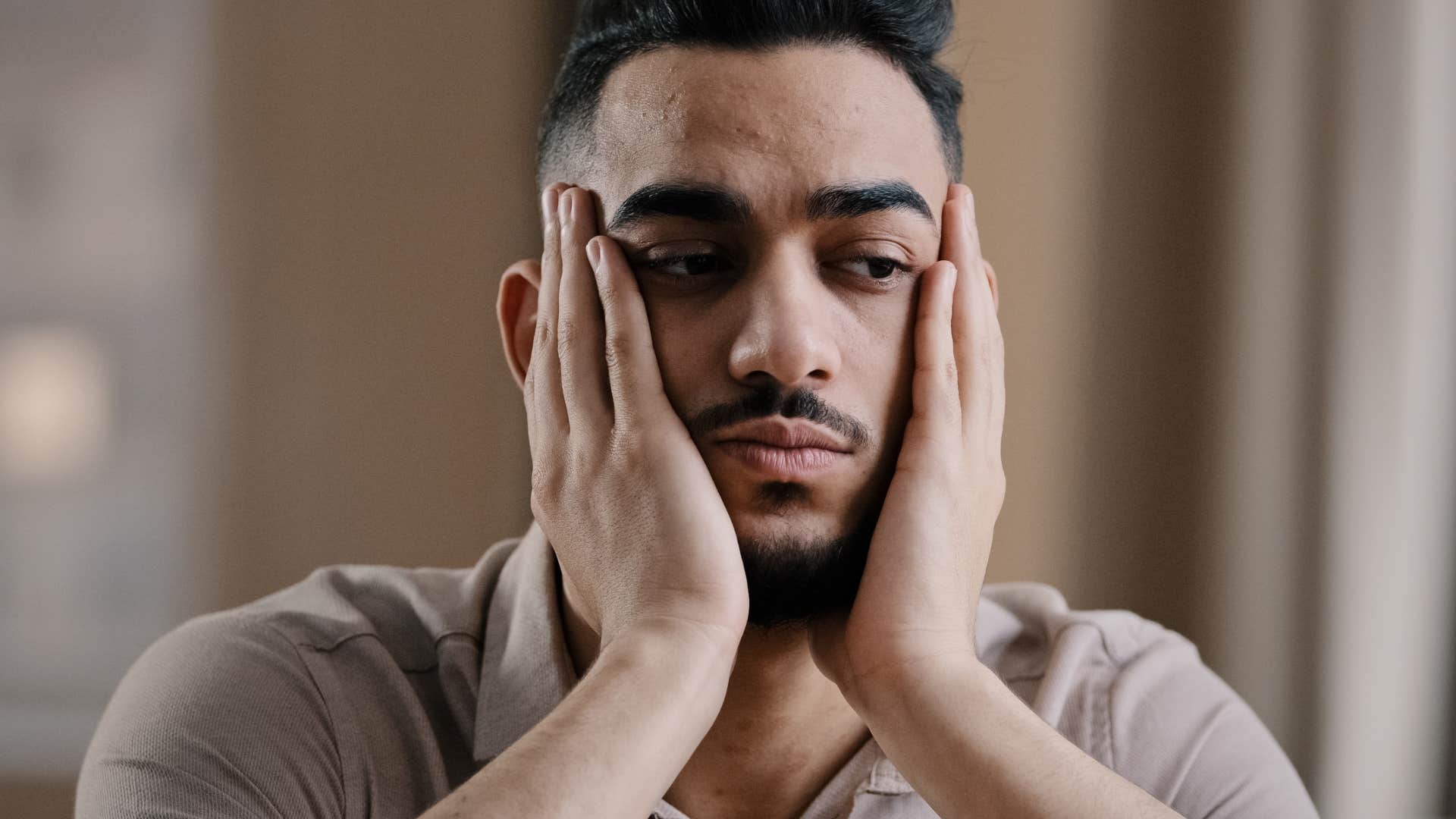 sad man stifling his own dreams sitting alone