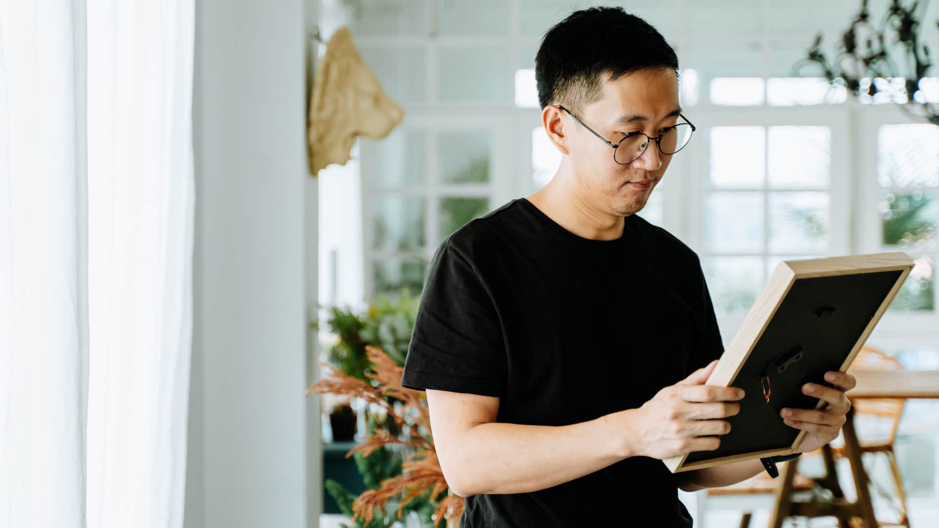 man looking at photo thinking about the past