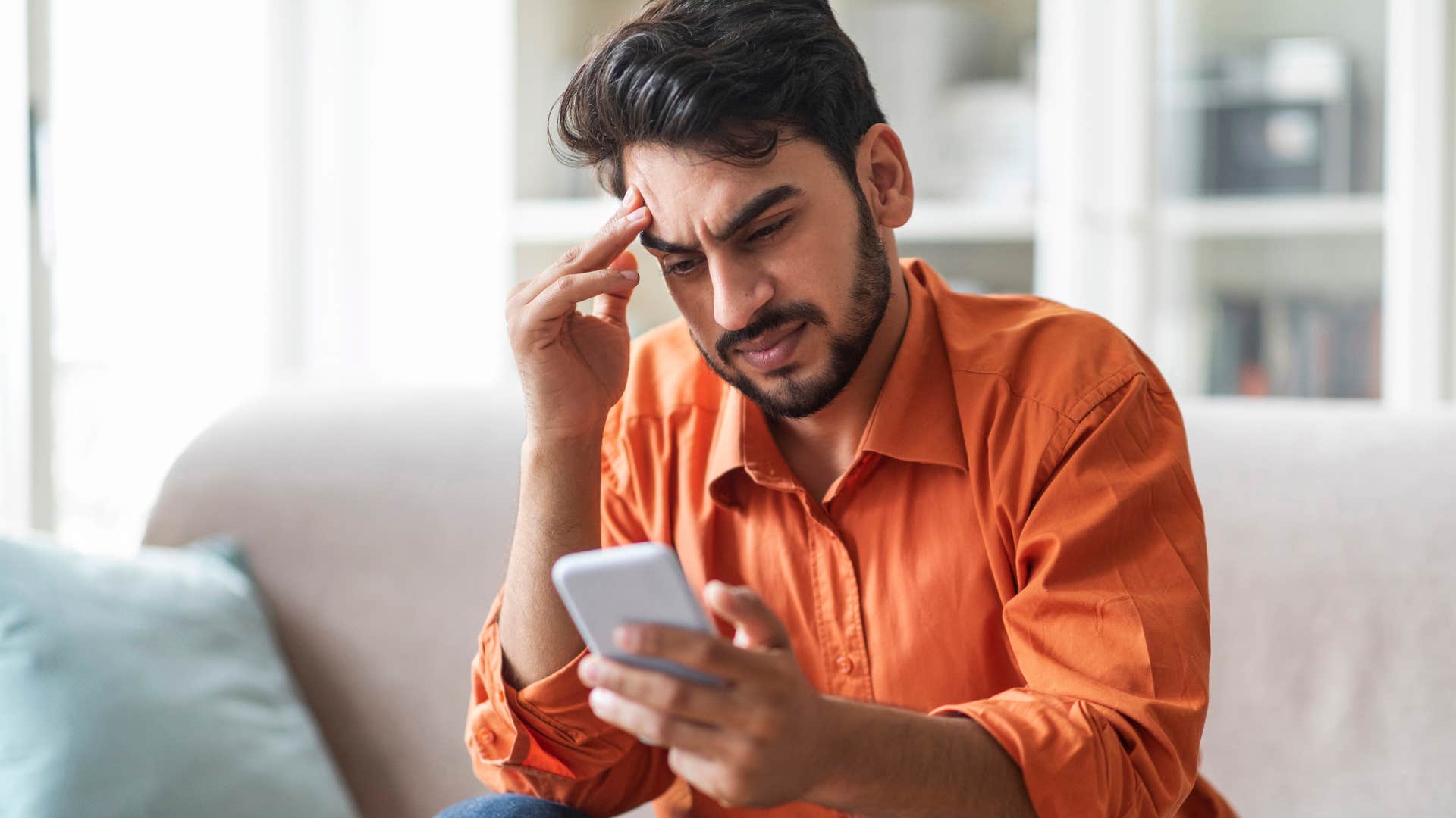 man who's uncomfortable with compliments looking at his phone