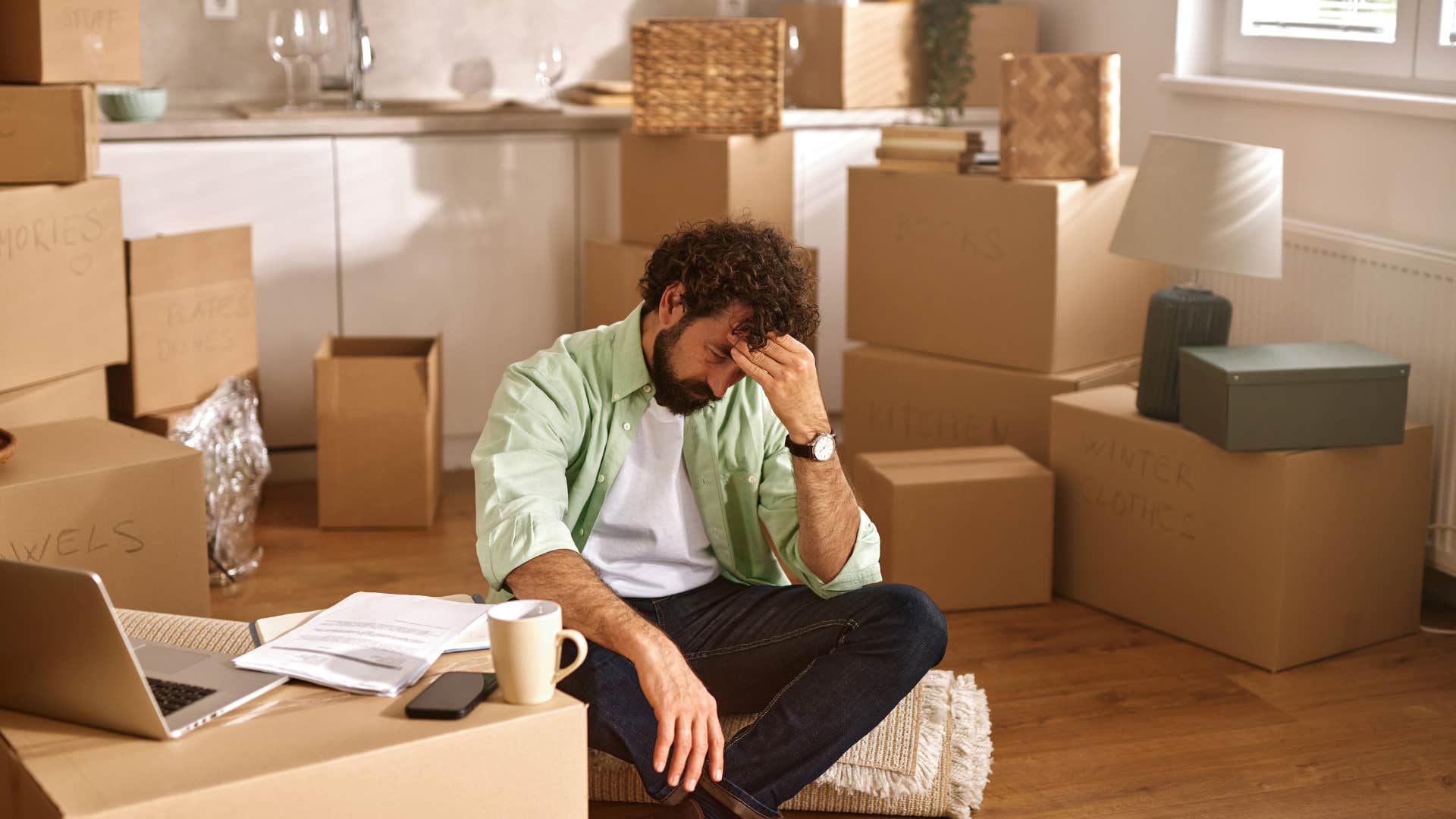 man sitting in cluttered living room