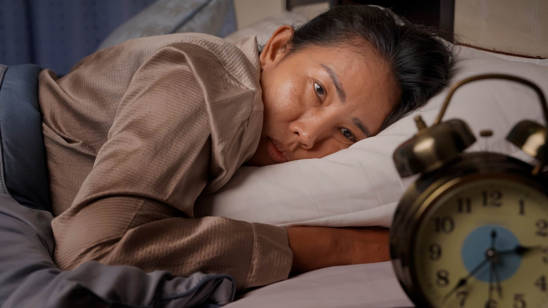 millennial woman in bed feeling guilty for resting